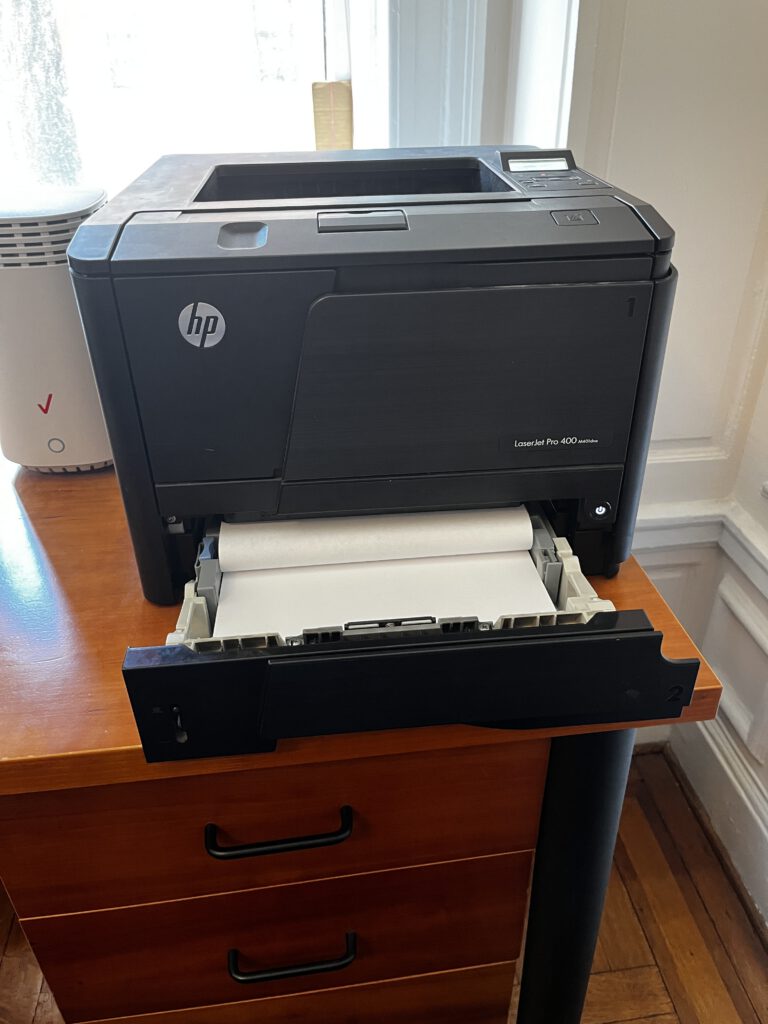 HP LaserJet Pro 400 M401dne printer with open paper tray during an on-site service visit in New York City to troubleshoot feed roller issues