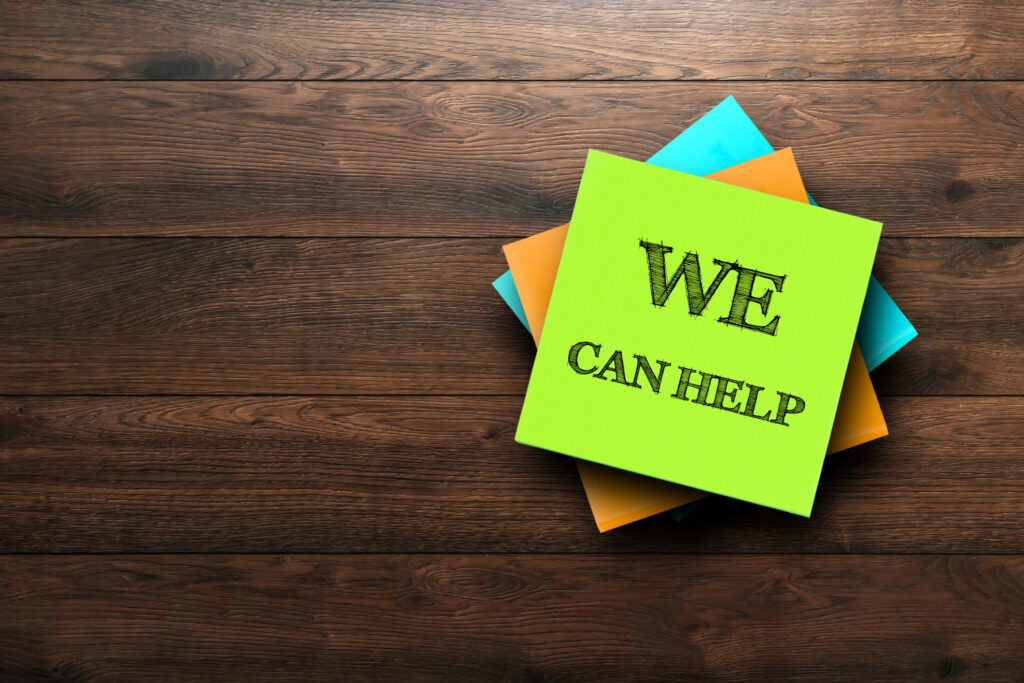 Bright sticky note on wood surface with the message 'We Can Help' — symbolizing approachable local tech support from MarcB I