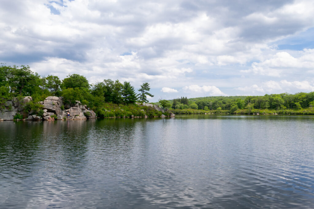 Tranquil lake surrounded by lush trees and rocky shoreline at Harriman State Park, New York