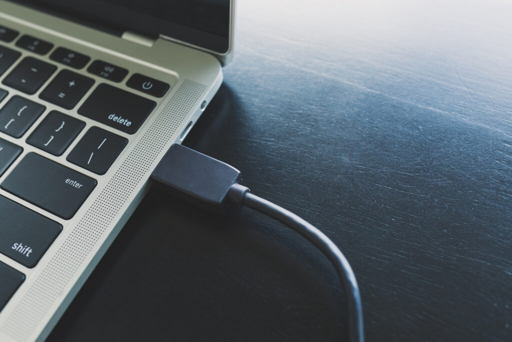 Close-up of a laptop connected with an HDMI cable, representing IT troubleshooting by MarcB IT